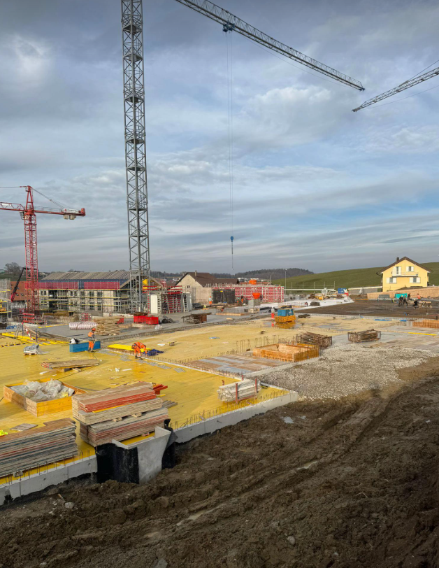 Baustelle mit Kran und laufenden Hochbauarbeiten